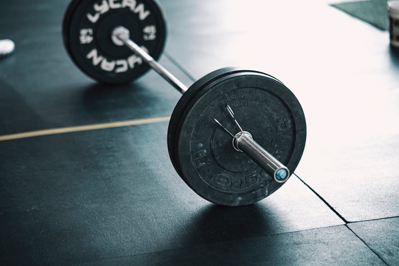 A detailed image of a barbell resting on a gym floor, perfect for fitness themes.
